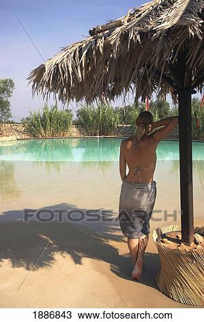 Woman In Bikini And Sarong Leaning Against Umbrella By Pool View Large Photo Image Stock Image - Woman In Bikini And Sarong Leaning Against Umbrella By Pool. Fotosearch
