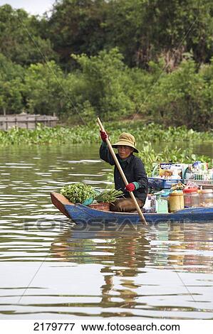 Stock Photo - Woman in Canoe on Tonle Sap Lake Cambodia. Fotosearch