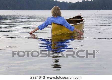 Stock Image - Woman In Canoe Trailing Hand In Water, Algonquin Park, Ontario, Canada. Fotosearch