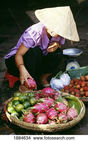 Picture - Woman In Conical Hat With Produce In Binh Tay Market. Fotosearch
