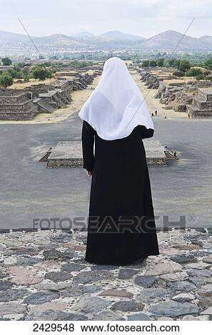 Woman in Islamic dress looking over the Avenue of the Dead from the Pyramid of the Moon, at Pyramids of Teotihuacan; San Juan Teotihuacan, State of Mexico, Mexico View Large Photo Image Stock Photo - Woman in Islamic dress looking over the Avenue of the Dead from the Pyramid of the Moon, at Pyramids of Teotihuacan; San Juan Teotihuacan, State of Mexico, Mexico. Fotosearch