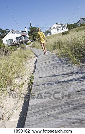 Woman In Kaftan Walking Towards Houses On Beach Wooden Walkway View Large Photo Image Stock Image - Woman In Kaftan Walking Towards Houses On Beach Wooden Walkway. Fotosearch