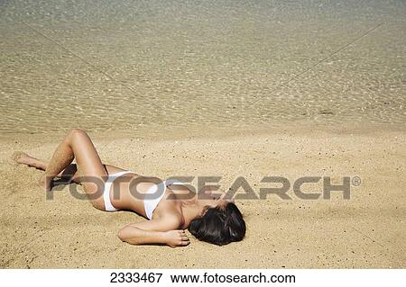 Woman in strapless white bathing suit laying out on the beach; Kauai, Hawaii, United States of America View Large Photo Image Stock Photo - Woman in strapless white bathing suit laying out on the beach; Kauai, Hawaii, United States of America. Fotosearch