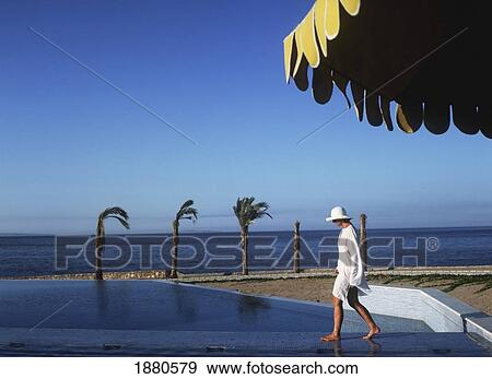 Woman In Sun Hat And Kaftan Waking Along Beach At Oberoi Sahl Hasheesh Resort View Large Photo Image Stock Photo - Woman In Sun Hat And Kaftan Waking Along Beach At Oberoi Sahl Hasheesh Resort. Fotosearch