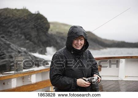 Woman In The Rain, Holding A Camera; Island Of Arran, Scotland View Large Photo Image Stock Photo - Woman In The Rain, Holding A Camera; Island Of Arran, Scotland. Fotosearch