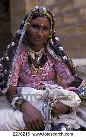 Stock Photograph - Woman in traditional clothes with baby, Jaisalmer, Rajasthan, India. Fotosearch