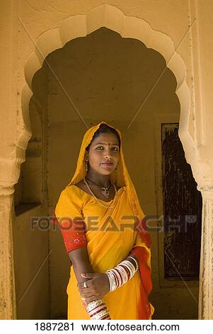Stock Image - Woman In Yellow Sari In Archway Of Old Building. Fotosearch