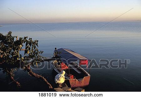 Woman Kneeling By Boat At Lake Tana View Large Photo Image Stock Photo - Woman Kneeling By Boat At Lake Tana. Fotosearch