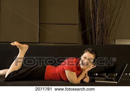 Woman Laying On A Couch Laughing With A Laptop, Toronto, Ontario View Large Photo Image Stock Image - Woman Laying On A Couch Laughing With A Laptop, Toronto, Ontario. Fotosearch