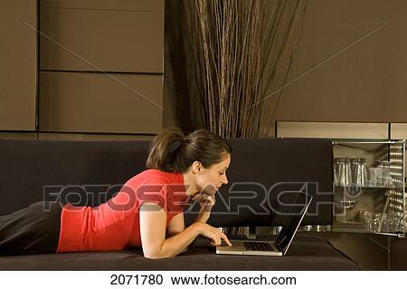 Woman Laying On A Couch On A Laptop, Toronto, Ontario View Large Photo Image Stock Image - Woman Laying On A Couch On A Laptop, Toronto, Ontario. Fotosearch