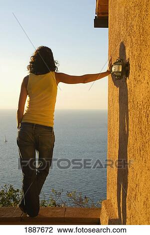 Woman Leaning Against Building Looking At Sea View Large Photo Image Stock Image - Woman Leaning Against Building Looking At Sea. Fotosearch