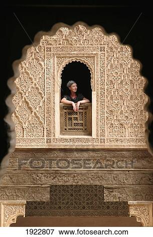 Stock Photo - Woman Leaning Out Of Window Of Ali Ben Youssef Medersa, Marrakesh, Morocco. Fotosearch