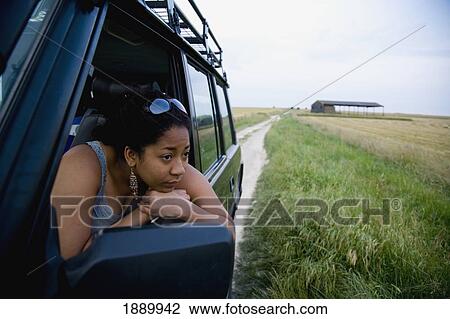 Stock Image - Woman Leaning Out Window Of Jeep. Fotosearch