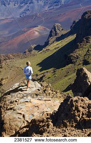 Stock Photo - Woman looking at the cinder cones from the Kalahaku Overlook, Haleakala Natonal Park; Maui, Hawaii, United States of America. Fotosearch