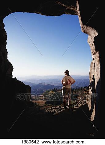 Stock Image - Woman Looking Over Rock Landscape. Fotosearch