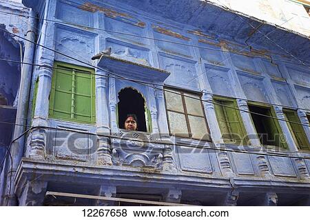 Stock Photo - Woman looks out window; Jodhpur, Rajasthan, India. Fotosearch