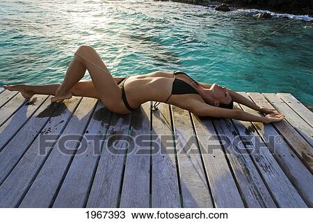 Woman Lounging On Resort Pier. View Large Photo Image Stock Image - Woman Lounging On Resort Pier.. Fotosearch