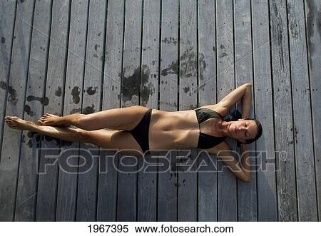 Stock Photography - Woman Lounging On Resort Pier.. Fotosearch