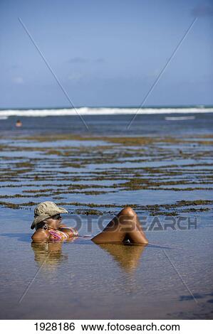 Woman Lying Partially Submerged In Rockpool, Praia Do Forte, Bahia, Brazil View Large Photo Image Stock Photograph - Woman Lying Partially Submerged In Rockpool, Praia Do Forte, Bahia, Brazil. Fotosearch