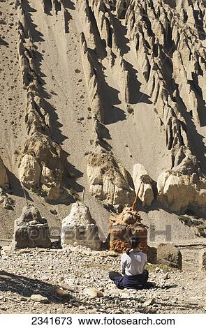 Stock Image - Woman Meditating In Front Of Chortens (Stupas); Tangbe, Upper Mustang Valley, Nepal. Fotosearch