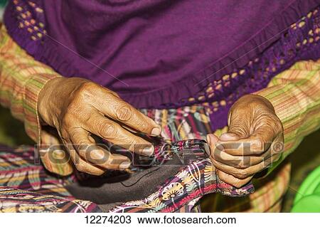 Stock Image - Woman mending a garment at a lurik workshop in Cawas village, Klaten, Central Java, Indonesia. Fotosearch