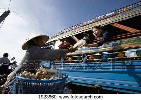 Stock Image - Woman Offering Food For Sale On Board Ferry Crossing The Mekong River, Si Phan Don In Southern Laos. Fotosearch