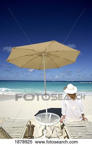 Woman On Beach Sitting On Sunlounger Under Umbrella View Large Photo Image Stock Photography - Woman On Beach Sitting On Sunlounger Under Umbrella. Fotosearch