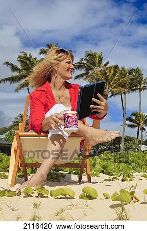 Woman on beach uses electronic tablet. View Large Photo Image Stock Image - Woman on beach uses electronic tablet.. Fotosearch