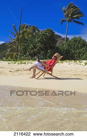 Woman on beach uses electronic tablet. View Large Photo Image Stock Image - Woman on beach uses electronic tablet.. Fotosearch