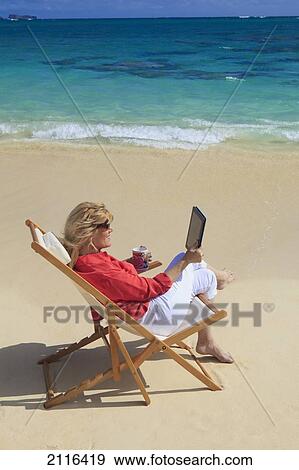 Woman on beach uses electronic tablet. View Large Photo Image Stock Photo - Woman on beach uses electronic tablet.. Fotosearch
