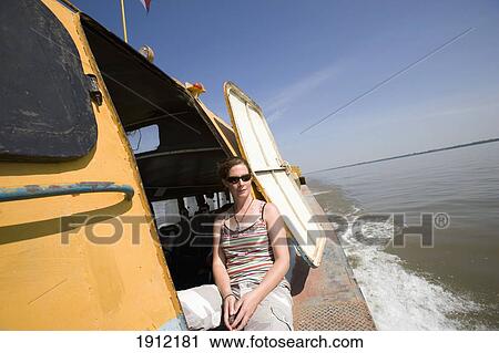 Stock Image - Woman On Boat On Mekong River, Cambodia/Vietnam Border, Vietnam. Fotosearch