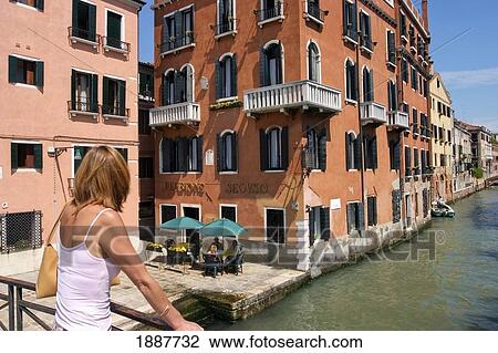 Stock Image - Woman On Bridge Overlooking Canal. Fotosearch
