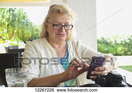 Stock Photograph - Woman on cell phone at Kukuiula Mall; Kauai, Hawaii, United States of America. Fotosearch