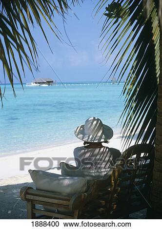 Stock Image - Woman On Chair On Beach. Fotosearch