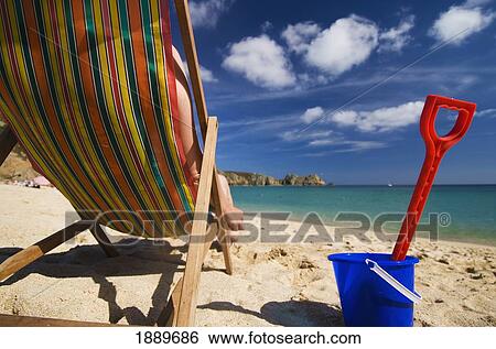 Woman On Deck Chair Beside Plastic Bucket And Spade On Porthcurno Beach View Large Photo Image Stock Photograph - Woman On Deck Chair Beside Plastic Bucket And Spade On Porthcurno Beach. Fotosearch