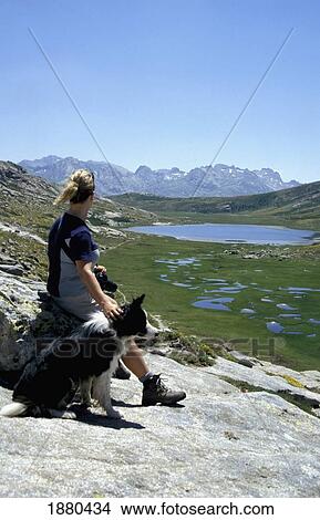 Picture - Woman On Gr20 Petting Dog. Fotosearch