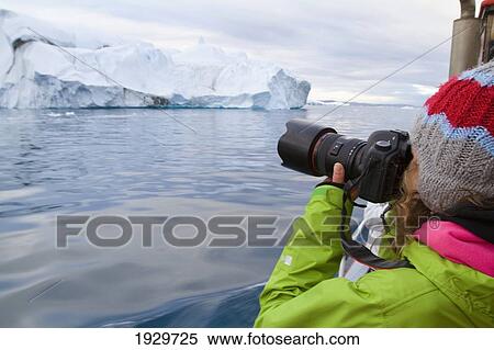 Stock Photography - Woman On Midnight Cruise Around The Ilulissat Ice Fjord, One Of Unesco World Heritage Sites. Greenland.. Fotosearch