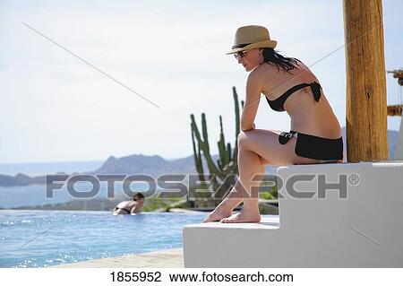 Stock Image - Woman On Terrace Poolside, Cabo San Lucas, Mexico. Fotosearch