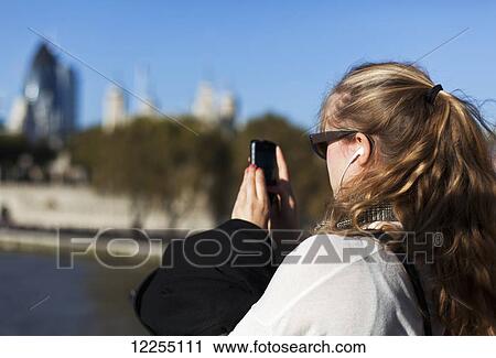 Woman on Tower Bridge overlooking the River Thames, the buildings of the City of London and the Tower of London; London, England View Large Photo Image Stock Image - Woman on Tower Bridge overlooking the River Thames, the buildings of the City of London and the Tower of London; London, England. Fotosearch
