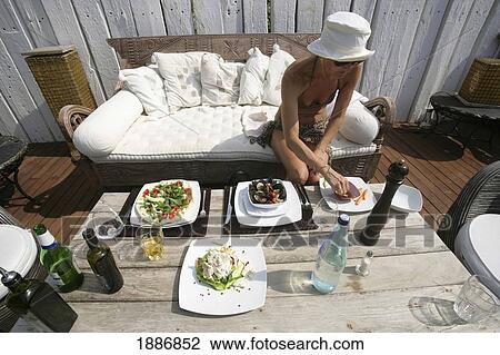 Woman On Wicker Sofa Eating Her Lunch On A Deck View Large Photo Image Stock Image - Woman On Wicker Sofa Eating Her Lunch On A Deck. Fotosearch