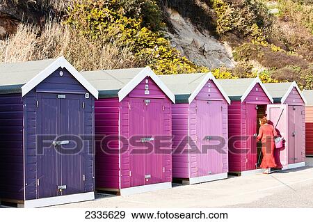 Stock Photo - Woman Opening Beach Hut At Bournemouth Beach; Bournemouth, Dorset, England. Fotosearch