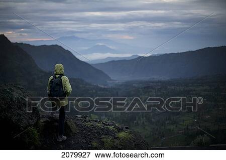 Woman Overlooking A Valley With Volcanos In The Background Early In The Morning; Cemoro Lawan Java Indonesia View Large Photo Image Stock Photo - Woman Overlooking A Valley With Volcanos In The Background Early In The Morning; Cemoro Lawan Java Indonesia. Fotosearch