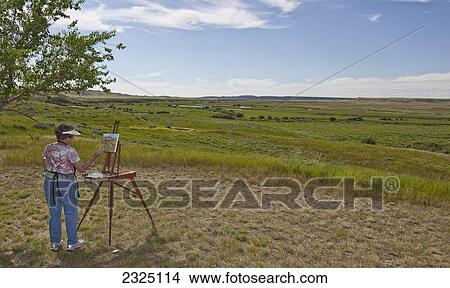 Picture - Woman Painting The Landscape In Grasslands National Park, Saskatchewan, Canada. Fotosearch