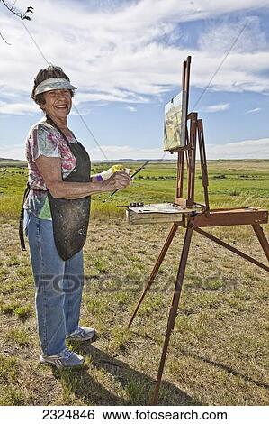 Stock Photograph - Woman Painting The Landscape In Grasslands National Park, Saskatchewan, Canada. Fotosearch