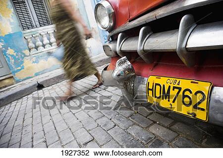 Stock Image - Woman Passing Old American Yank Tank. Fotosearch
