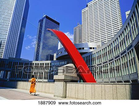 Stock Photo - Woman Passing Tokyo Metropolitan Government Building. Fotosearch
