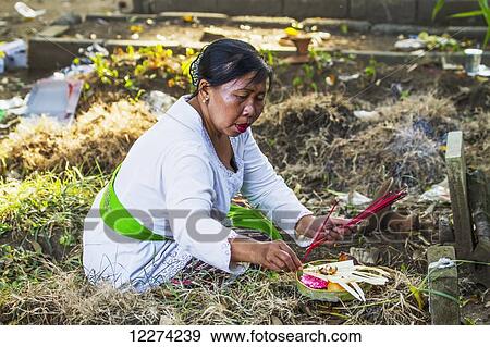 Woman placing an offering on a grave during a Ngaben or Cremation Ceremony, Klungkung, Bali, Indonesia View Large Photo Image Stock Photo - Woman placing an offering on a grave during a Ngaben or Cremation Ceremony, Klungkung, Bali, Indonesia. Fotosearch