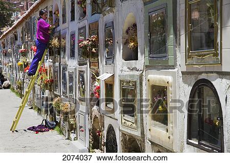 Stock Photo - Woman Placing Flowers In A Niche In The Cementerio General De La Paz Cemetery, La Paz, Bolivia. Fotosearch