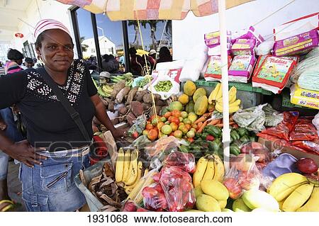 Stock Photo - Woman poses with fruit and vegetables stall in Kingstone on St Vincent Island. St Vincent and the Grenadines in Caribbean., St Vincent and the Grenadines in Caribbean.. Fotosearch