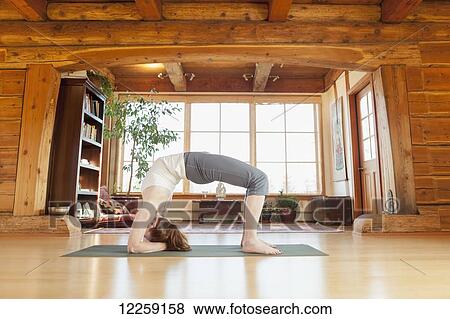 Stock Photo - Woman practices yoga at indoor studio, Homer, Alaska. Fotosearch